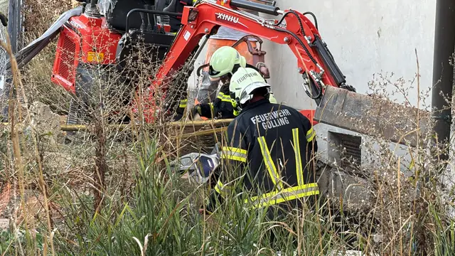 Für die Einsatzkräfte galt es zunächst, die umgestürzte Baumaschine zu sichern und eine weitere Gefahr im Bereich der Hausmauer zu verhindern. | Foto: DOKU NÖ
