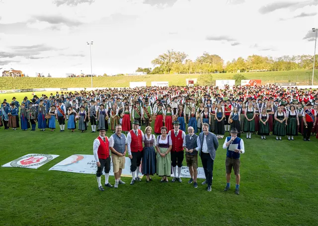 Landeshauptfrau Johanna Mikl-Leitner mit Bürgermeisterin Michaela Hinterholzer (5. von rechts), Bürgermeister Christian Haberhauer (2. von links) sowie mehr als 700 Musikantinnen und Musikanten am Fußballplatz in Mauer. | Foto: NLK Khittl