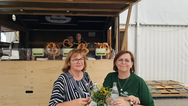 Die Freundinnen Margarete und Uli sitzen gemütlich vor dem Breznstand im Zelt. | Foto: Elke Rott/zema-medien.de