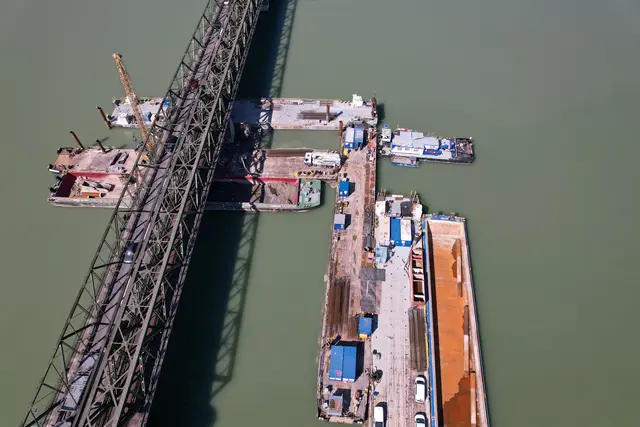 Baumaschinen und Materialien werden über eine mit dem Ufer verbundene Arbeitsplattform im Wasser zu den Pfeilern transportiert. | Foto: ÖBB/Pointner
