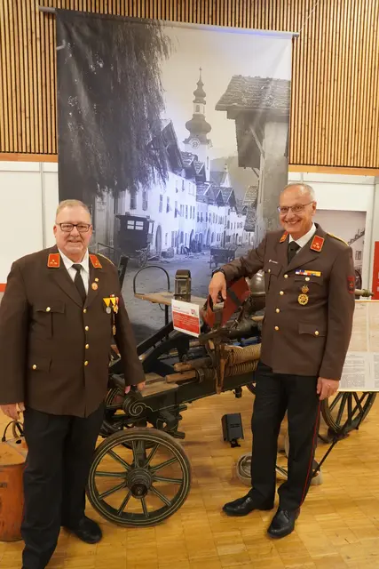 Robert Kaufmann (re.) und Christian Nocker, die ehemalige Führungsspitze der FF Zirl, mit historischen Geräten und einem erst kürzlich entdeckten uralten Foto, das einen eindrucksvollen Einblick in das Zirl von früher - vor dem Großbrand - gibt. | Foto: Georg Larcher / MeinBezirk