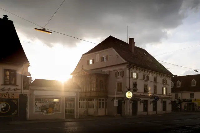 Straßenszene am Griesplatz in Graz mit historischen Gebäuden bei Sonnenuntergang und bewölktem Himmel
