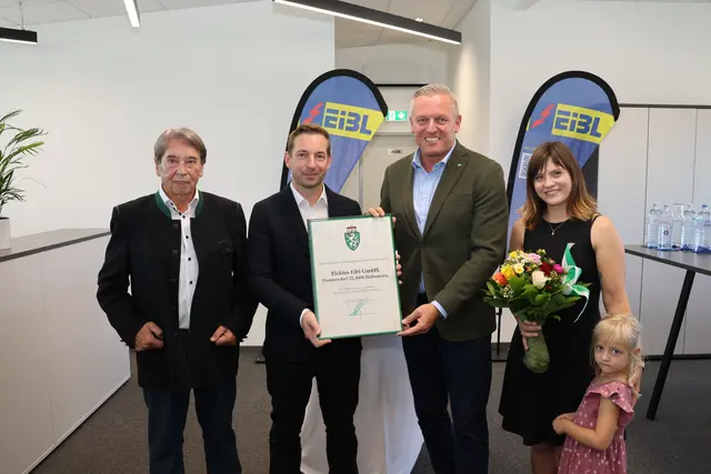 Vier Personen stehen bei der Überreichung einer Auszeichnung nebeneinander