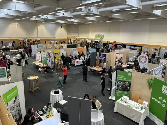 Messehalle mit Ständen und Besucherinnen und Besuchern