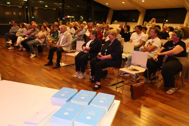 Menschen sitzen im Saal