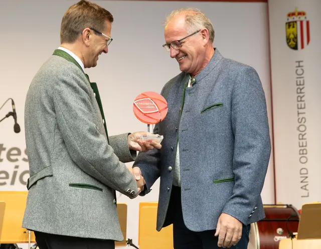 Landesrat Markus Achleitner (l.) zeichnet Schönaus Bürgermeister Herbert Haunschmied mit dem Ortsbildpreis 2026 aus. | Foto: Land OÖ/Pelzl