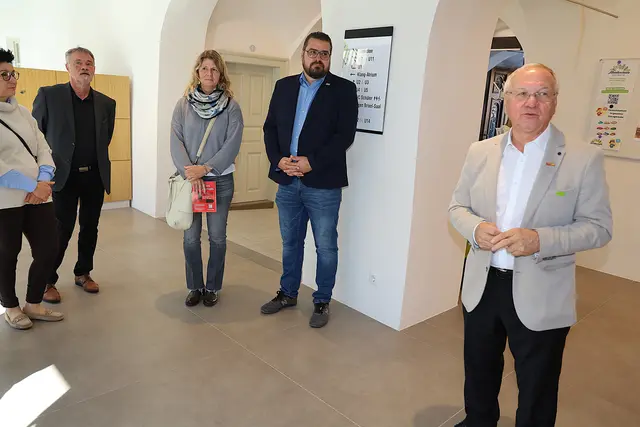 Fünf Personen stehen in einem Gebäude.