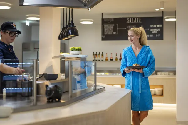 Eine Frau im Bademantel in einem Selbstbedienungsrestaurant
