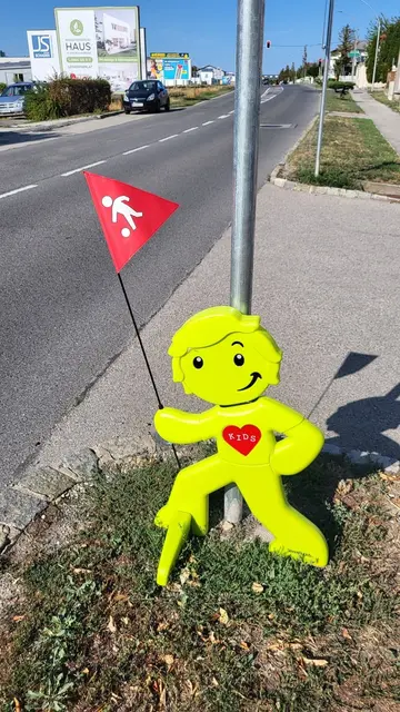 Gelbe Plastikfigur am Straßenrand