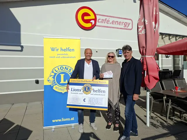 Zwei Männer und eine Frau mit einem symbolischen Spendenscheck.
