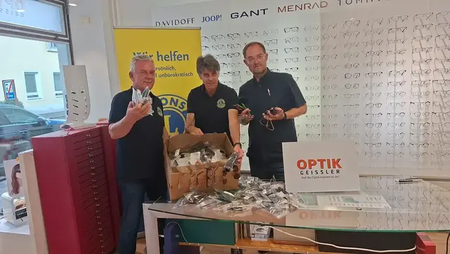 Drei Männer mit Brillen in der Hand