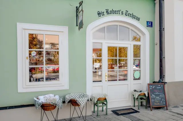 Die zartgrüne Fassade, die weißen Fenster und die Körbe vor der Tür geben ein harmonisches Motiv. | Foto: Gerald Lang Photography