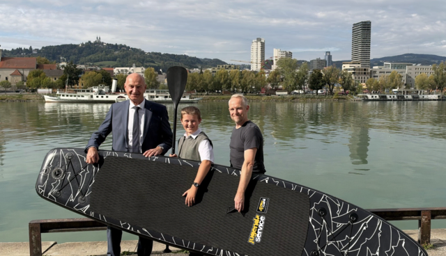 Jugend-Landesrat Christian Dörfel (l.) übergibt gemeinsam mit dem Geschäftsführer der 4-You-Card Markus Aspalter (r.) dem Gewinner Manuel Pilgerstorfer aus Rainbach das Stand-Up-Paddle. | Foto: Land OÖ