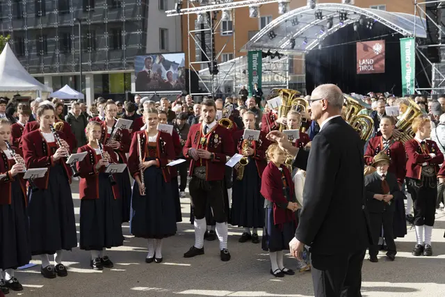 LH Anton Mattle beim Dirigieren am Landhausplatz. Die Musikerinnen und Musikerinnen zeigten dabei ihr Können.  | Foto: Land Tirol/ Die Fotografen