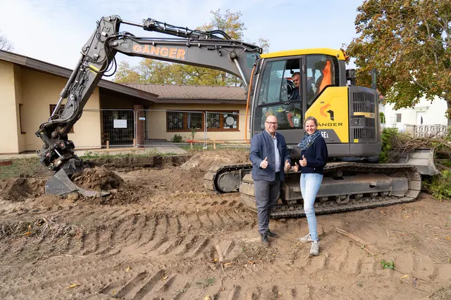 Bürgermeister Markus Mentl-Weigl und Kindergartenleiterin Michaela Fedorczuk (v. l. n. r.) vor der Baustelle; im Hintergrund ein Bagger samt Baggerfahrer. | Foto: Stadtgemeinde Deutsch-Wagram