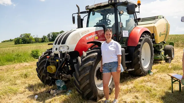 Frau vor Traktor am Feld