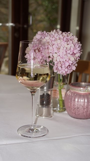 Glas Weißwein mit Tischdeko