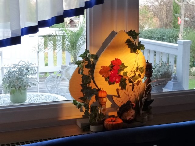 Durchs Fenster wirft das Licht der Abendsonne seinen Strahl auf die Deko im Haus.