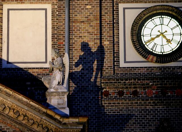 ...einer der beiden flankierenden Engel am Hauptportal der Breitenfelder Pfarrkirche...wirft seinen Schatten...
