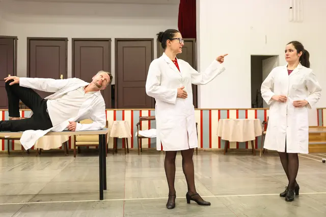 Im Bild das medizinische Personal auf der Klavierhauptprobe: Dieter Kschwendt-Michel als Dr. Maximilian Notnagel, Maida Karišik als Direktorin Regine Schellpfeffer und Ewelina Jurga als Pflegerin Mira.

Abendsonne. Kammeroper mit einem Text von Kristine Tornquist und mit Musik von Tomasz Skweres (UA)

10., 12., 13., 14., 15., 16., 17. November 2025, jeweils 19.30 Uhr | 80 Minuten. Keine Pause
Jugendstilheater, Baumgartner Höhe 1, 1140 Wien | Bar Bio Weingut Gsellmann am Goldberg
LIMITS. Eine Vortragsreihe, an allen Vorstellungstagen frei zugänglich, jeweils um 18.30 Uhr

Eine sirene-Produktion bei WIEN MODERN im Jugendstiltheater | Ensemble PHACE

Die Seniorenresidenz Abendsonne bedeutet für die alten Bewohner die Endstation ihres Lebens, für das junge Pflegepersonal viel Arbeit, für die Leitung ein ausbaufähiges Geschäftsmodell. Unruhe entsteht, als Büxenstein eine Krebsdiagnose erhält. Als pensionierter Arzt weiss er, dass er nur noch wenig Zeit hat. Nach einem Gespräch mit Stella, die sich in metaphysischen Fragen auskennt, verfestigt sich in ihm die Idee, seine Wiedergeburt in die Wege zu leiten. Seine Freunde Hagedorn und Sägebarth sind nach einigen Zweifeln bereit, ihm zu helfen. Nach Stellas Rezept braucht man nur ein junges Liebespaar - also planen sie, die junge Pflegerin Mira und den neuen Pfleger Mirko zu verkuppeln. Büxenstein schreibt sein Testament, in dem er Mira und ihr zukünftiges Kind - also sich selbst - reich bedenkt. Und tatsächlich, die beiden jungen Menschen verlieben sich ineinander. Stella ist in die Pläne nicht eingeweiht, aber sie liest drohendes Unheil aus den Karten und macht sich Sorgen. Als das Liebespaar von den alten Herren endlich in die Liebesnacht gelotst wird, scheint der Plan aufzugehen. Im letzten Moment kommt es anders... Eine Tragikomödie des Überlebens von Tomasz Skweres (Musik) und Kristine Tornquist (Libretto und Regie), erstmalig auf die Bühne gebracht vom sirene Operntheater. | Foto: Barbara Pálffy