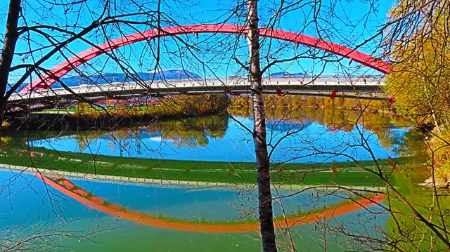Die Rote Brücke über die Drau in Villach, im Hintergrund der schneebedeckte Dobratsch.
