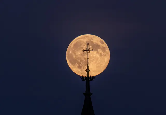 Mondleuchte in eiserner Fassung - so erscheint der Supermond bei richtiger Einstellung hinter dem Turmkreuz der Pfarrkirche Raabs 
