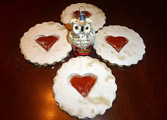 Linzer Augen sind ein traditionelles, aus Linz stammendes Gebäck, das zum „Linzer Teig“ gehört und mit Johannisbeer- oder Marillenmarmelade gefüllt wird, wobei ein Ausschnitt die Marmelade wie ein „Auge“ freigibt. Ihre Geschichte ist eng mit der Linzer Torte verbunden, die mit ihrem ältesten bekannten Rezept von 1653 die Grundlage für den berühmten Linzer Teig legte, der auch für die Kekse verwendet wird. Die „Augen“ sind eine festliche Variante und ein beliebtes Weihnachtsgebäck in Österreich, auch bekannt als „Spitzbuben“ 💖