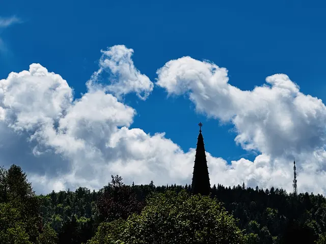 DAS GRÜN DER BÄUME GIBT NUR MEHR DIE SICHT AUF DEN TURM DER EVANGELISCHEN KIRCHE FREI